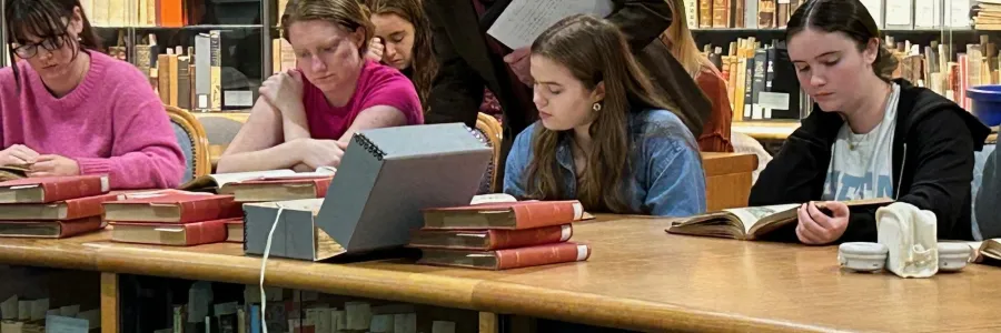 Prof. West and students look at books