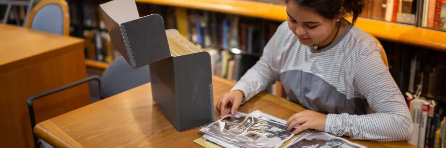 Student looking at photographs from the archives